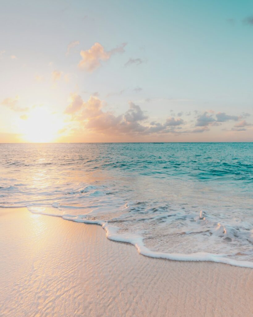 Gentle waves on a sandy beach under a low sun