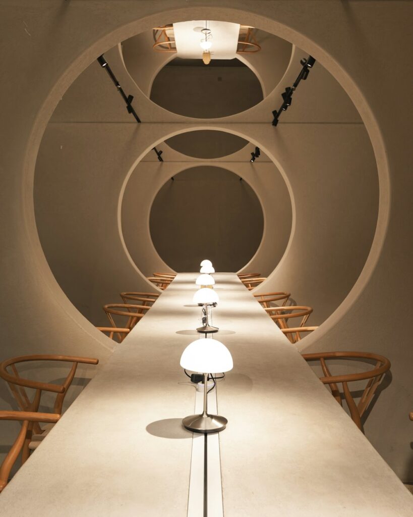 Long table with lamps and wooden chairs in a room with arched ceilings