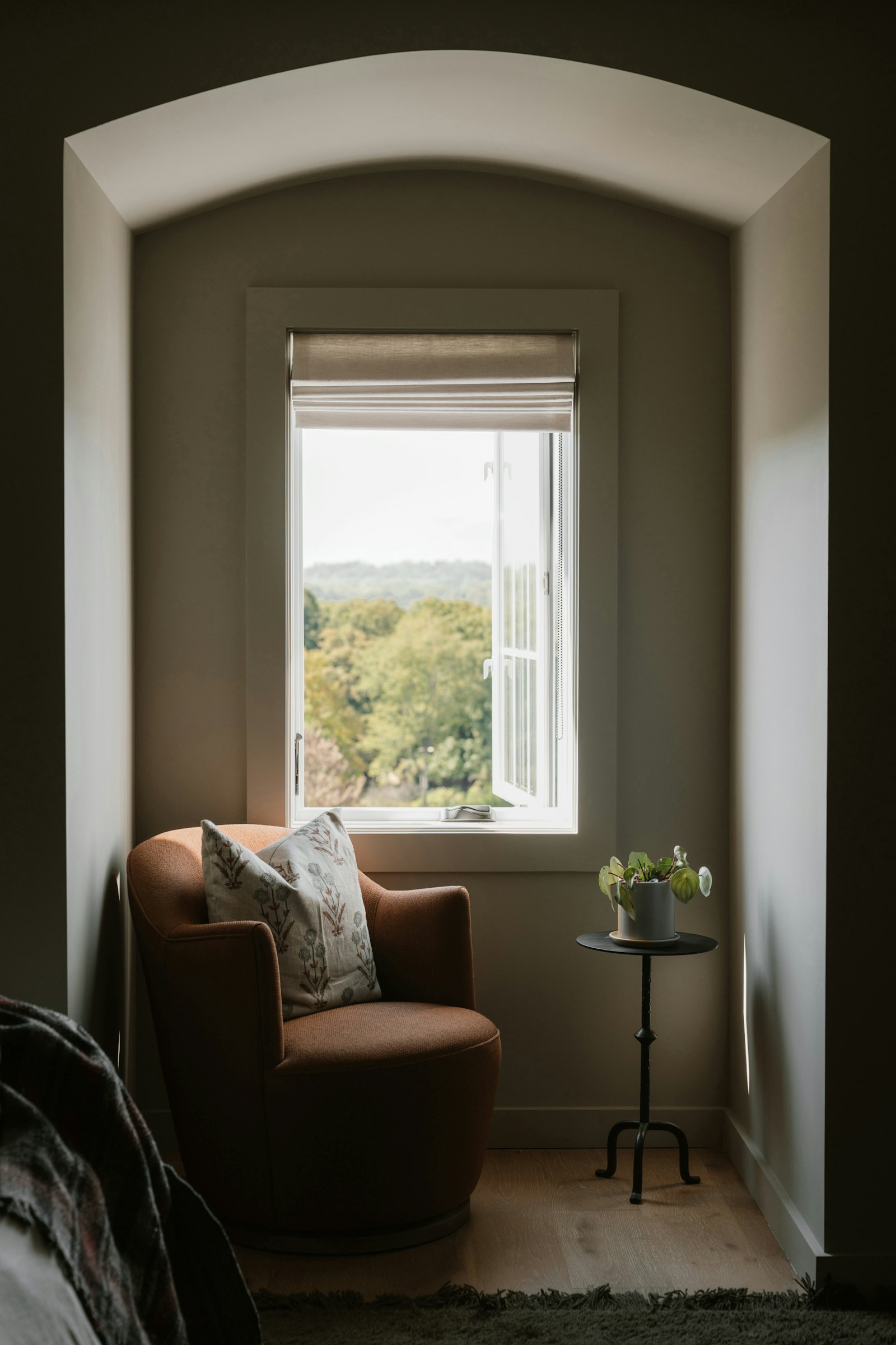 Armchair beneath a small window in a quiet, arched alcove